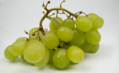 Fresh green grapes isolated on pink background. Selective focus on the fresh green grapes..
