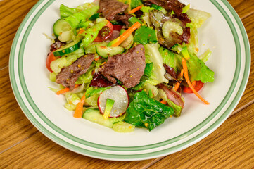 Fried meat with vegetables. Salad with meat, tomatoes, peppers, cucumbers and salad