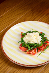 Spring vegetable salad with tomatoes on white plate