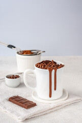 Chocolate mug cake in white cup with chocolate drops and coca powder