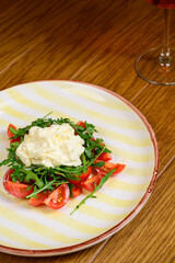 Spring vegetable salad with tomatoes on white plate