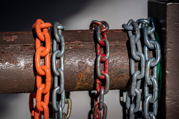 Colorful chains hang on a rusted steel gate at a forest service road in the mountains. 