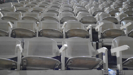 Weiße graue Stühle, Sitze in einem Stadion