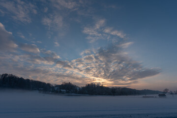 Obraz na płótnie Canvas Sonnenuntergang auf dem Land b ei Nebel und Schnee im Winter mit Feld, Wald, Wolken