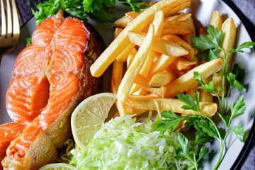 salmon steaks with potato fries and coleslaw