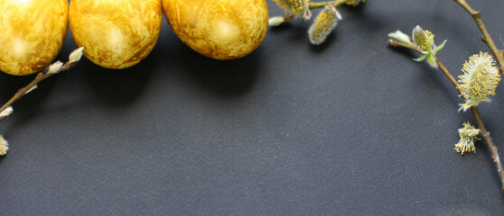 Easter background with golden eggs and willow on a black background. Template for poster, advertisement, poster, postcard. Happy Easter background top view, copy space