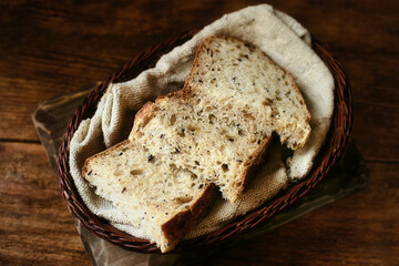 Pieces of sliced bread lie in a wicker basket on a wooden table. Fresh homemade baking of yeast-free bread with your own hands. Top view