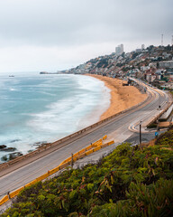 Vista panorámica desde el mirador de Reñaca con olas chocando contra la playa y los autos pasando...