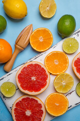 Fresh various citrus fruits on a blue background, top view