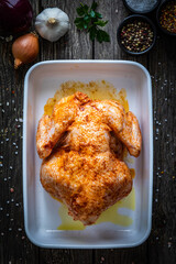 Fresh raw chicken on wooden table prepared to roast

