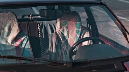 The seats of a red vintage car covered in colorful towels (Marche, Italy, Europe)