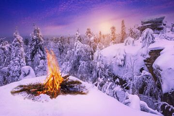 Panoramic landscape with purple color, mountains, forest, bonfire, sunrise and snow cover. Ural,...