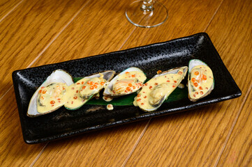 Oysters with red caviar on wooden background