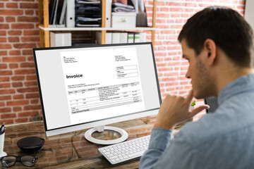 Fototapeta na wymiar Businessman Checking Invoice On Computer