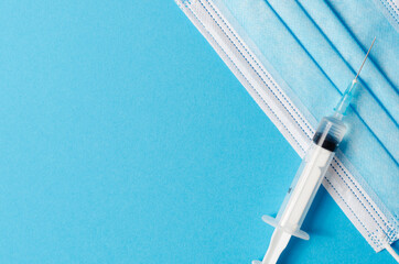 Syringe and mask on a blue background. Place for the test.