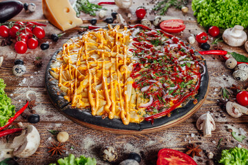 The pizza is surrounded by raw ingredients on the boards