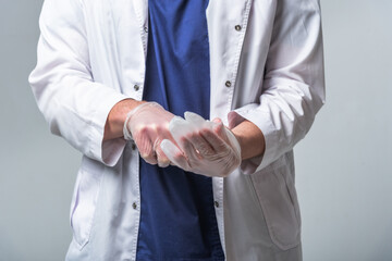 Closeup of a doctor's hands in medical clothing who puts gloves on his hands. Health and protection concept