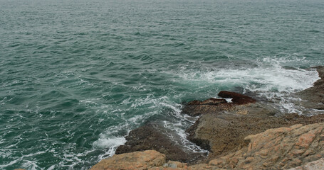 Ocean waves splash against rocks
