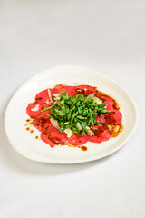 Vegetable vegetarian salad with tomatoes, peppers and onions on white table.