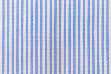 Striped textile pattern of a blue white business shirt. Fabric structure closeup of fashion...