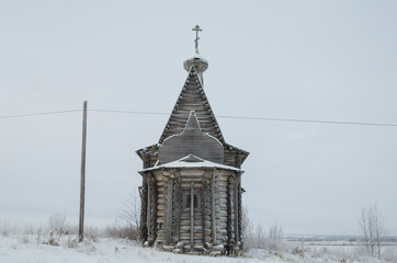Fototapeta na wymiar December, 2020 - Chukhcherma. The ancient wooden church of St. Basil the Blessed in the northern village. Russia, Arkhangelsk region, the village of Srednepogostskaya