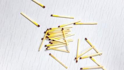 A few matches scattered on a wooden white background. Copy space.
