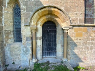 Fototapeta na wymiar Old stone arched doorway, with a wooden door in, Farnham, Harrogate, UK