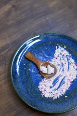 pink salt on a blue ceramic plate on a wooden table