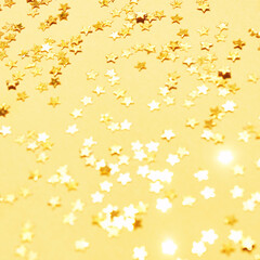 Gold stars background. Yellow glitter backdrop. Golden texture. New year luxury snow. Copyspace. Shimmer confetti wallpaper. Dreamy shiny design detail
