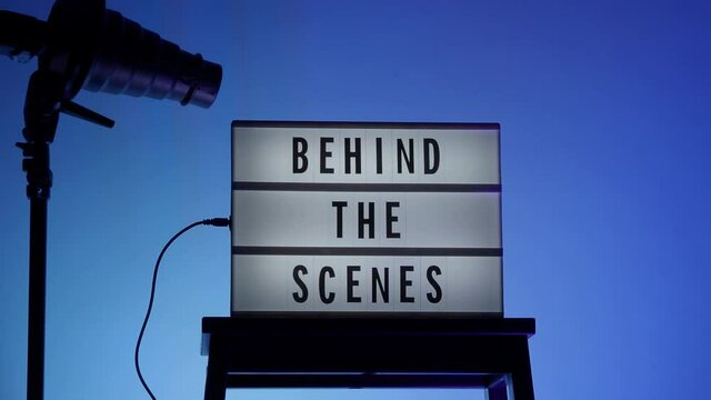 Cinema Light box. Behind the scenes letterboard text on Lightbox. background LED color change loop. Snoot hood flash on tripod. static camera in video production studio. Behind the scene Lightbox