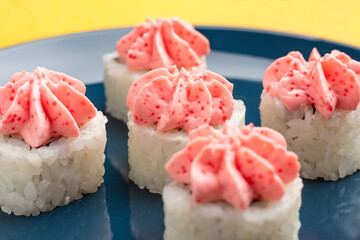 rolls with pink Lava sauce on a dark blue plate. Close-up