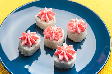 rolls with pink Lava sauce on a dark blue plate. Top view