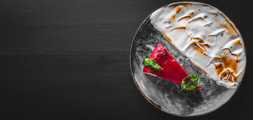 Strawberry cheesecake served on plate on black wooden table background