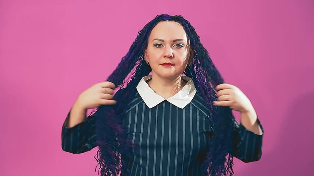 Stylish brunette Jewess with blue Afro braids fingering strands with her hands