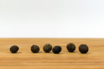 six peas of black allspice close up
