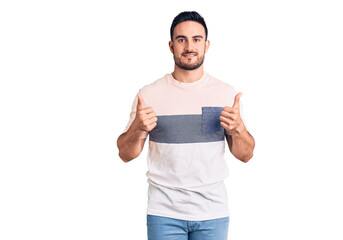 Young handsome man wearing casual clothes success sign doing positive gesture with hand, thumbs up smiling and happy. cheerful expression and winner gesture.