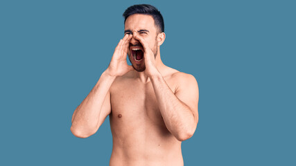 Fototapeta premium Young handsome man wearing swimwear shouting angry out loud with hands over mouth