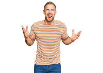 Young irish man wearing casual clothes crazy and mad shouting and yelling with aggressive expression and arms raised. frustration concept.