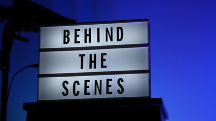 Cinema Light box. Behind the scenes letterboard text on Lightbox. Multi color LED on background. Sillhouette flash snoot hood on tripod. video production studio. Behind the scene Lightbox