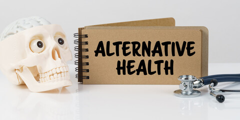 On the table lies a skull, a stethoscope and a notebook with the inscription - ALTERNATIVE HEALTH