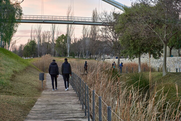 Personas paseando junto al lago del parque de Cabecera de Valencia al atardecer