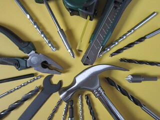 Obraz premium A Set of a lot of different green tools for working include hammer wrench bit pliers, screwdriver, paper knife, screwdriver nozzle, key on yellow background 
