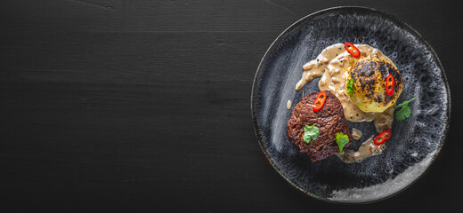 Grilled beef steak filet mignon with potato and sauce in plate on wooden table