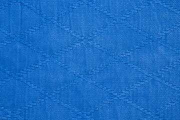 The texture of a cotton kimono for judo classes. Blue fabric close-up. The view from the top.