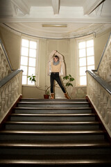 Obraz na płótnie Canvas girl posing in a hall with windows and stairs