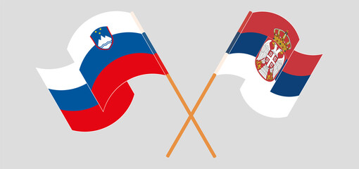 Crossed and waving flags of Slovenia and Serbia