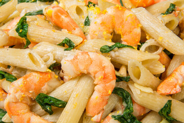 Pasta with shrimps, leeks and spinach with lemon zest. Close-up. 