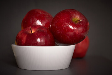 bright red apples in a white ceramic bowl