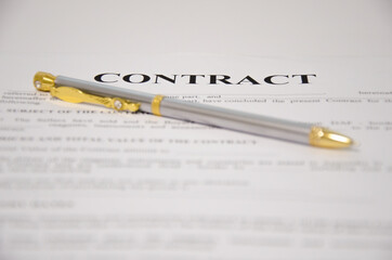 the pen is on the contract and the contract is on a white background