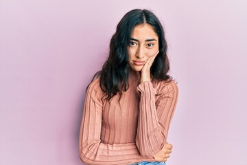 Hispanic teenager girl with dental braces wearing casual clothes thinking looking tired and bored...